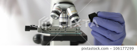 Scientist working with pipette and microscope in laboratory. Scientist working with pipette and microscope in laboratory. 106177299