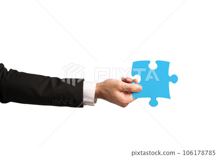 businessman holds a piece of puzzle as teamwork, partnership, integration concept 106178785