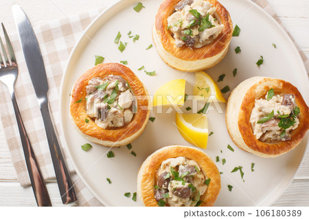 Delicious classic vol-au-vent stuffed with chicken, mushrooms in a creamy sauce close-up in a plate. horizontal top view 106180389