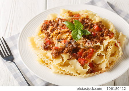 Tasty homemade Reginette Bolognese pasta closeup on the plate on the white table. Horizontal Tasty homemade Reginette Bolognese pasta closeup on the plate on the white table. Horizontal 106180412