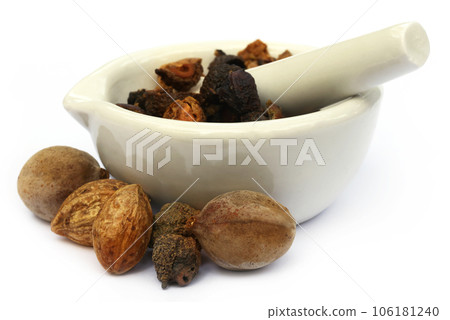 Triphala, a combination of ayurvedic fruits with mortar and pestle 106181240