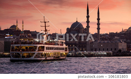 Famous Istanbul ferry boat going in Bosphorus at sunset against mosques and evening sky. 15th of March, 2023, Turkey, Istanbul. 106181803