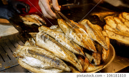Closeup of dish full of roasted grilled fish. Cooking famous Turkish dish Balik Ekmek on street. 106181810