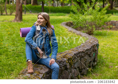Blonde young woman resting after long hiking and looking relaxed Blonde young woman resting after long hiking and looking relaxed 106183842