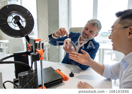 Innovative industrial engineers using 3D printer to build complex component. 106183898