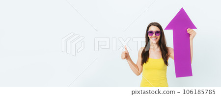 Cheerful young woman wearing colorful summer outfit holding big paper 106185785