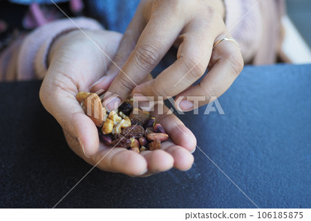 women hand pick many mixed nuts women hand pick many mixed nuts 106185875