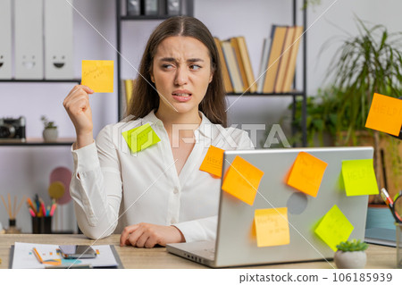 Tired sad exhausted businesswoman working on laptop at office with many sticker tasks, panic attack Tired sad exhausted businesswoman working on laptop at office with many sticker tasks, panic attack 106185939