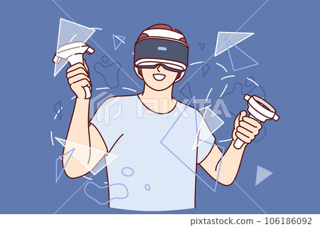 Guy with virtual reality headset, holds joysticks for video games and stands among broken glass 106186092