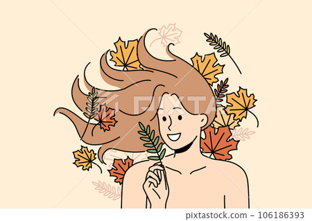 Woman with long flowing hair lies among autumn leaves and smiles rejoicing at onset of september 106186393