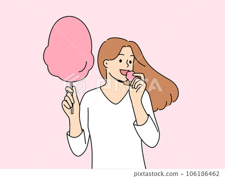 Woman eats cotton candy, enjoying airy sugar dessert while walking in park or at fair Woman eats cotton candy, enjoying airy sugar dessert while walking in park or at fair 106186462