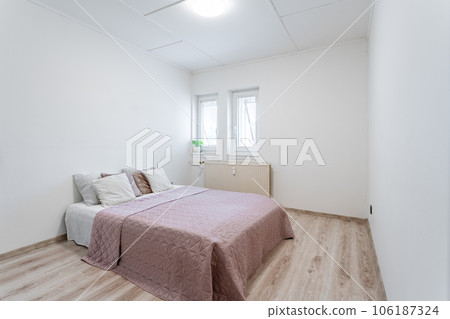 bed in a minimalist bedroom in an apartment of a residential building 106187324