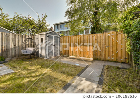 a backyard area with a swing in the middle part of the yard, and a wooden fence that is behind it a backyard area with a swing in the middle part of the yard, and a wooden fence that is behind it 106188630