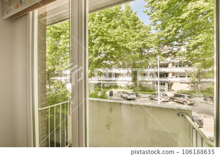 an outside area with trees and buildings in the background, taken from inside a window looking out onto the street an outside area with trees and buildings in the background, taken from inside a window looking out onto the street 106188635
