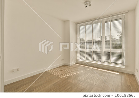 an empty room with wooden floors and white shutters on the windows, looking out onto the cityscapea 106188663