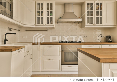 a kitchen with white cupboards and wood counter tops on the island in front of the sink is wooden top a kitchen with white cupboards and wood counter tops on the island in front of the sink is wooden top 106188671
