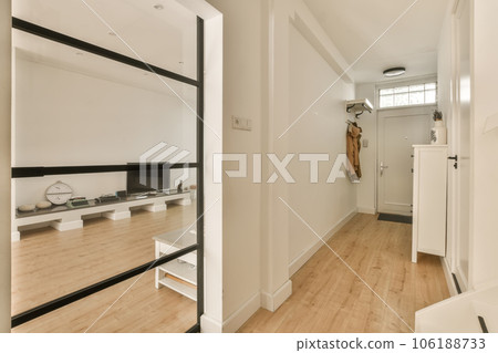 an empty room with wooden floors and white walls, there is a large mirror in the corner to the right an empty room with wooden floors and white walls, there is a large mirror in the corner to the right 106188733