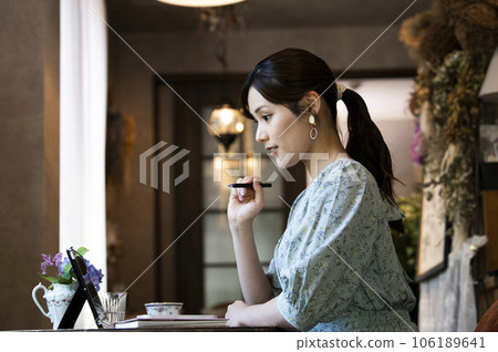 一位年輕女子在咖啡館使用平板電腦的個人資料 106189641