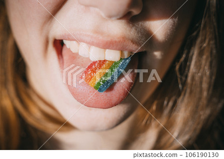 A plate of Rainbow marmalade on the tongue of a teenage girl in the sunlight 106190130