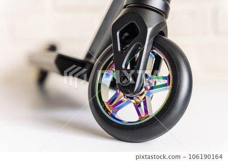 Front view of a stunt scooter with rainbow-colored wheels 106190164