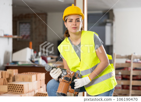Young woman construction worker standing inside apartment 106190470