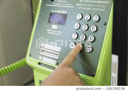 Child hand making a call from a public phone Child hand making a call from a public phone 106190536