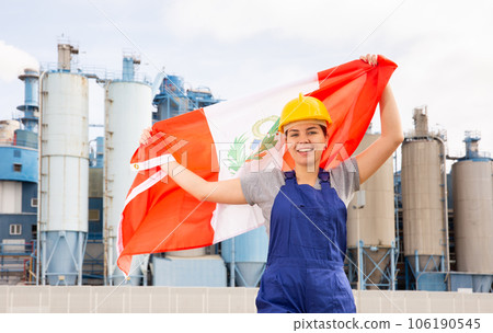 Young female engineer in helmet waving state flag of Peru while standing in front of big tanks at chemical plant Young female engineer in helmet waving state flag of Peru while standing in front of big tanks at chemical plant 106190545