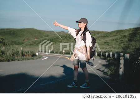 Woman with a backpack hitchhiking 106191052