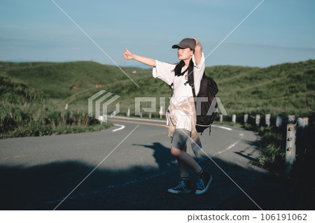 Woman with a backpack hitchhiking Woman with a backpack hitchhiking 106191062