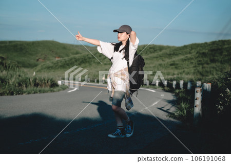 Woman with a backpack hitchhiking 106191068