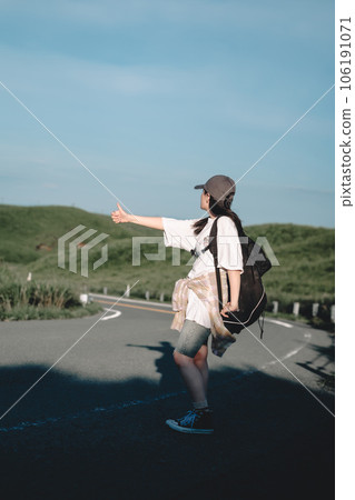 Woman with a backpack hitchhiking Woman with a backpack hitchhiking 106191071