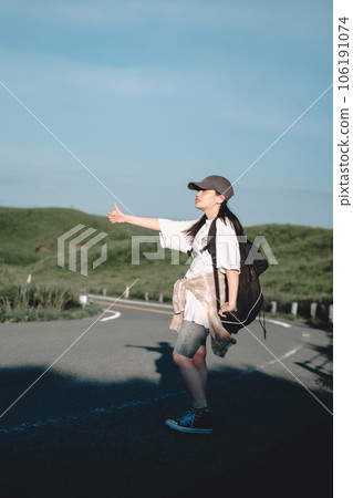 Woman with a backpack hitchhiking 106191074