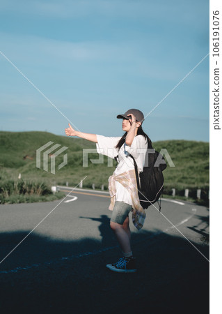 Woman with a backpack hitchhiking 106191076