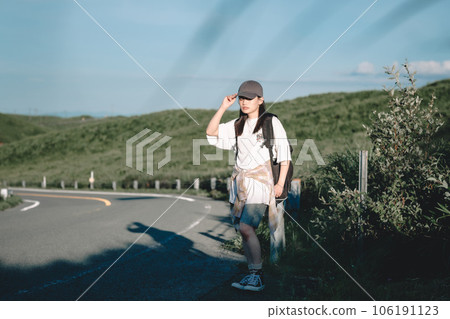Woman with a backpack hitchhiking 106191123