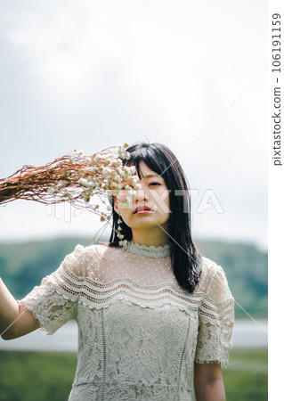 Woman holding a bouquet in the meadow 106191159