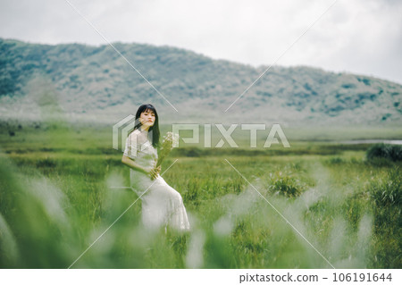 Woman sitting on a chair in the meadow Woman sitting on a chair in the meadow 106191644