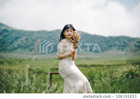 Woman sitting on a chair in the meadow 106191653