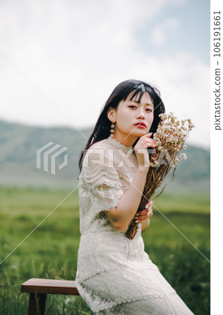 Woman sitting on a chair in the meadow 106191661