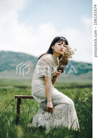 Woman sitting on a chair in the meadow 106191674