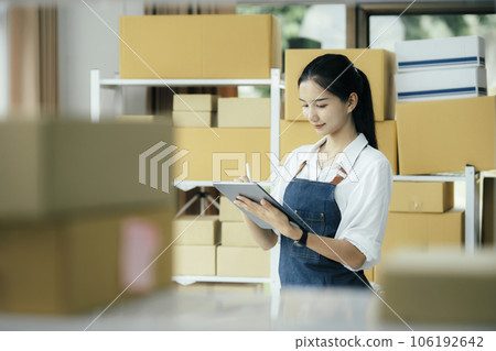 Happy entrepreneurs using tablets for check order and Checking stock for delivering products to customers. 106192642