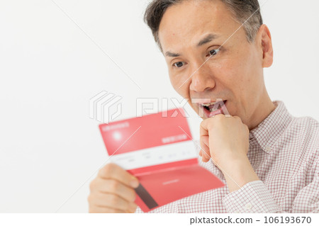 A man who is worried about looking at the passbook 106193670