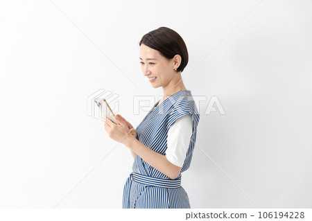 一個女人側身拿著智能手機 106194228