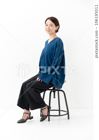 Woman sitting on a chair casual full body 106195011
