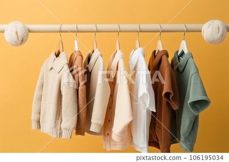 stylish baby clothes hanging on rack against color background 106195034