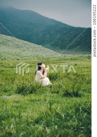 A woman in a white dress crouching on a meadow A woman in a white dress crouching on a meadow 106195222