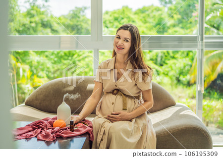 A serene moment captured as a pregnant woman after 40 embraces the soothing benefits of aroma oils and an aroma diffuser, enhancing her pregnancy journey with relaxation and tranquility A serene moment captured as a pregnant woman after 40 embraces the soothing benefits of aroma oils and an aroma diffuser, enhancing her pregnancy journey with relaxation and tranquility 106195309
