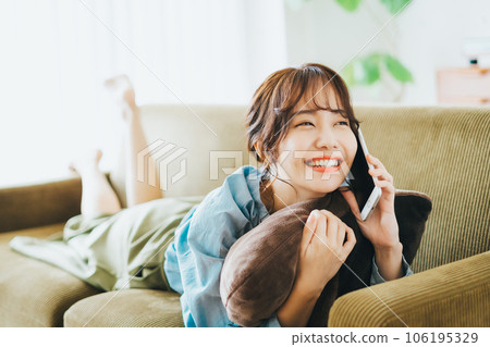 躺在沙發上打電話的女人 106195329