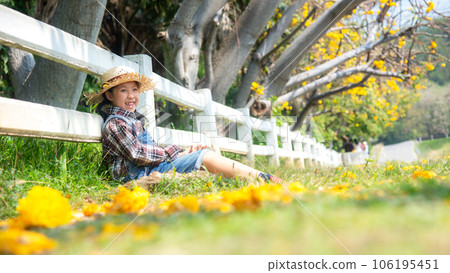 Asian kid girl sitting chill outdoor in fallen leaves autumn in meadow the park,  106195451