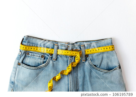 Planning for dieting healthy. Measure tape around waist jean for diet health. 106195789