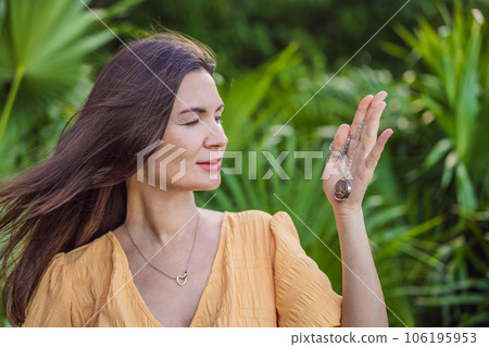 pregnant woman after 40 demonstrating the use of an aroma pendant, combining style and aromatherapy during her pregnancy journey 106195953